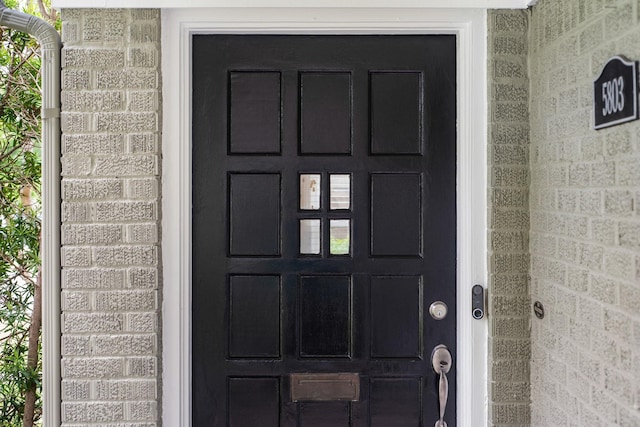 doorway to property with brick siding