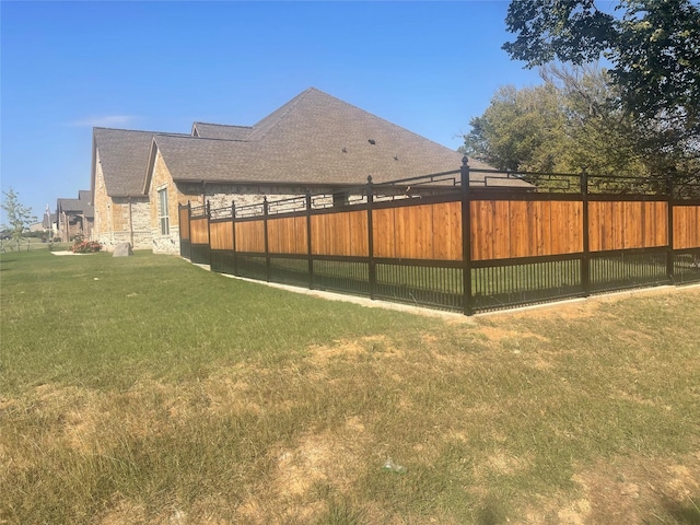 exterior space with stone siding, fence, and a lawn