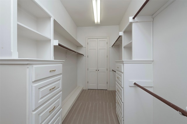 walk in closet featuring light carpet