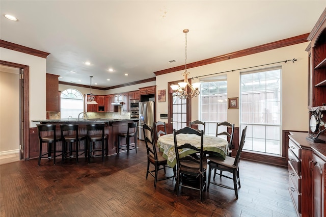 dining room featuring an inviting chandelier, ornamental molding, dark wood-style flooring, and recessed lighting