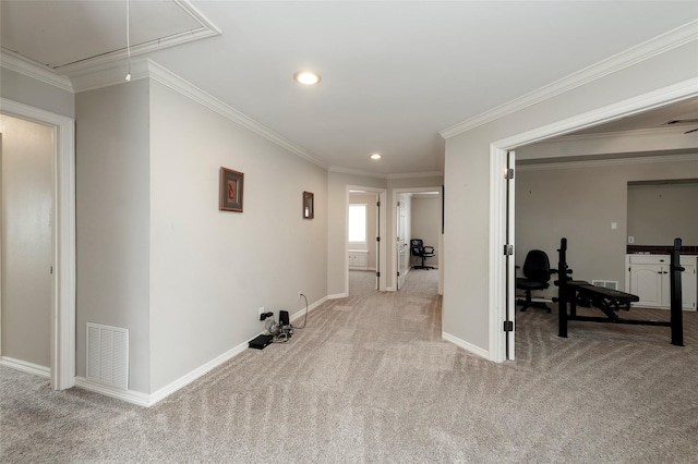 interior space with attic access, visible vents, baseboards, light carpet, and ornamental molding