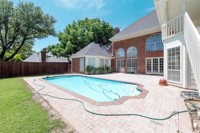 view of pool with french doors, a fenced in pool, an outdoor structure, a patio, and a fenced backyard
