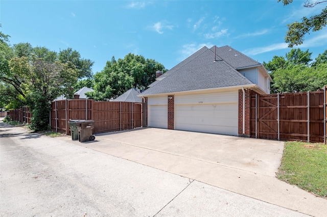 view of home's exterior with fence, a shingled roof, and brick siding