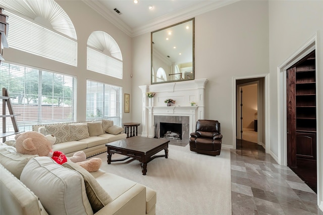 living area with crown molding, recessed lighting, a high ceiling, and a tiled fireplace