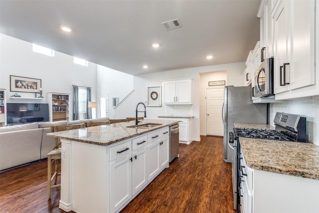 2224 Miramar Dr, Little Elm, TX 75068 - kitchen with appliances with stainless steel finishes, a sink, a breakfast bar area, open floor plan, and visible vents