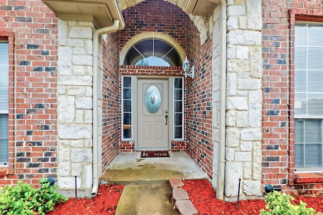 property entrance with stone siding and brick siding