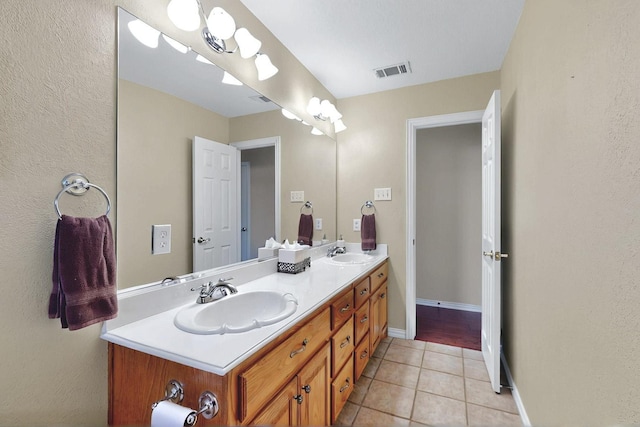 bathroom with double vanity, tile patterned floors, visible vents, and a sink