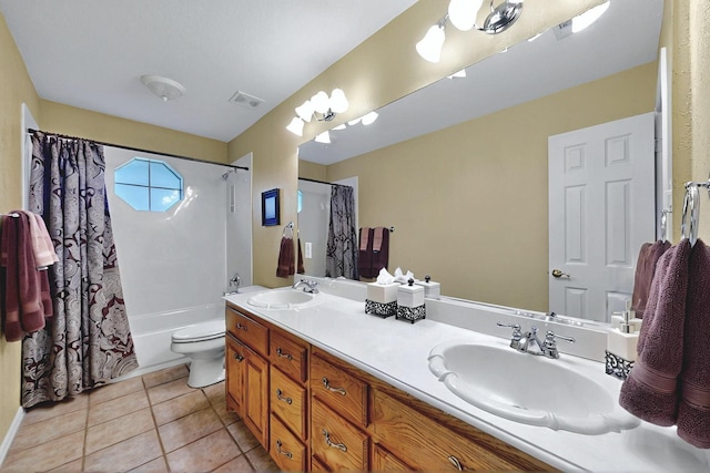 full bath featuring toilet, double vanity, tile patterned floors, and a sink