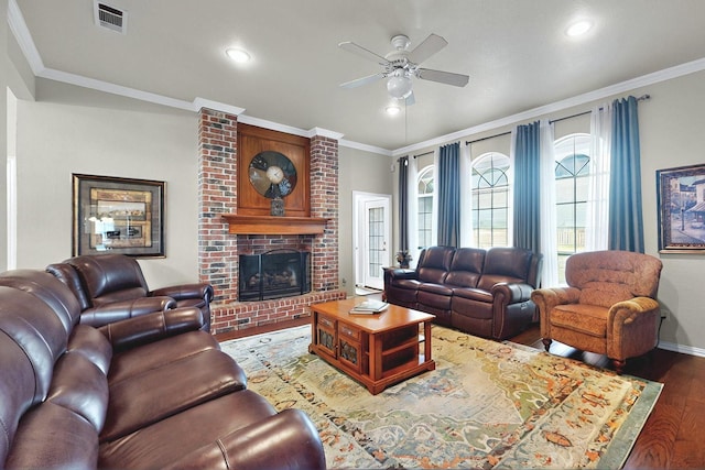 living area with ceiling fan, baseboards, wood finished floors, visible vents, and ornamental molding