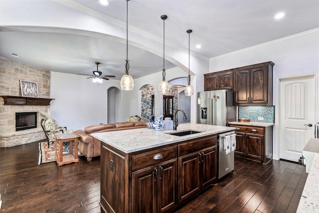245 Prairie Oak Ct, Burleson, TX 76028 - kitchen with stainless steel appliances, arched walkways, a sink, dark wood-style flooring, and crown molding