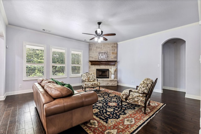 245 Prairie Oak Ct, Burleson, TX 76028 - living room with arched walkways, a ceiling fan, dark wood finished floors, crown molding, and a fireplace