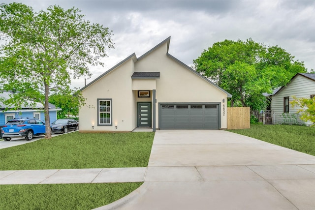 view of front facade with a garage, fence, concrete driveway, and a front yard