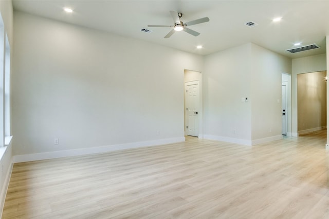 empty room featuring a ceiling fan, baseboards, visible vents, and light wood-type flooring