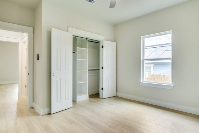unfurnished bedroom with baseboards, visible vents, light wood finished floors, and a closet