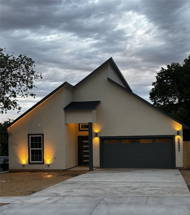contemporary house featuring a garage, stucco siding, and concrete driveway