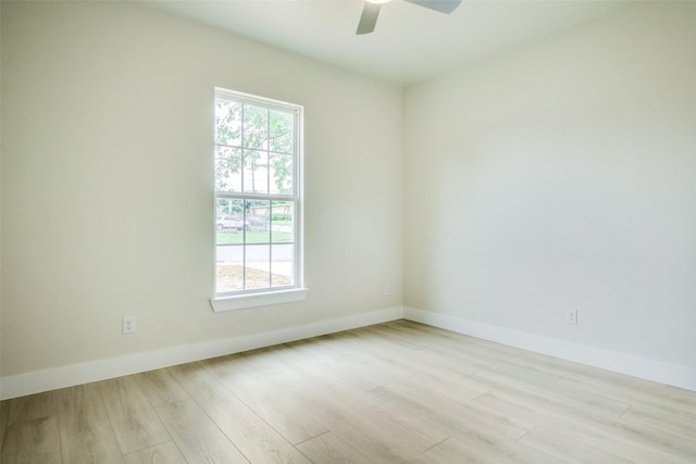 empty room featuring a ceiling fan, baseboards, a healthy amount of sunlight, and wood finished floors