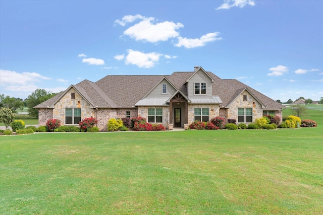 craftsman-style house featuring a standing seam roof, a front yard, and stone siding