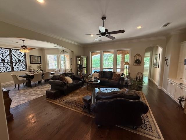 living area with crown molding, ceiling fan, arched walkways, dark wood finished floors, and recessed lighting