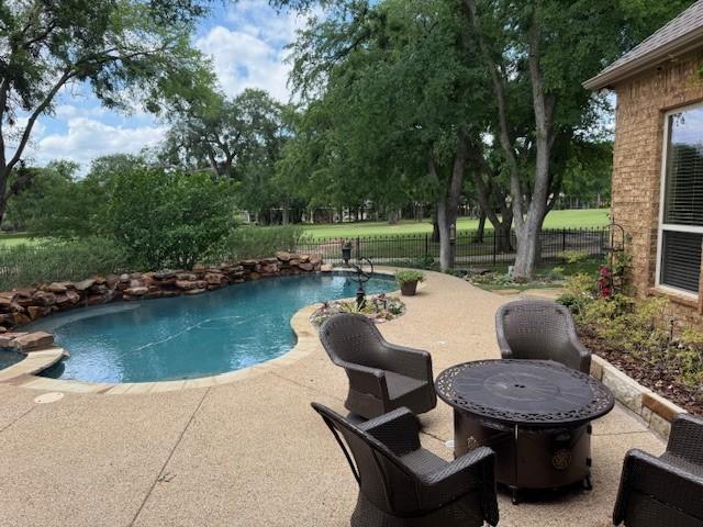 view of swimming pool featuring a patio, fence, and a fenced in pool