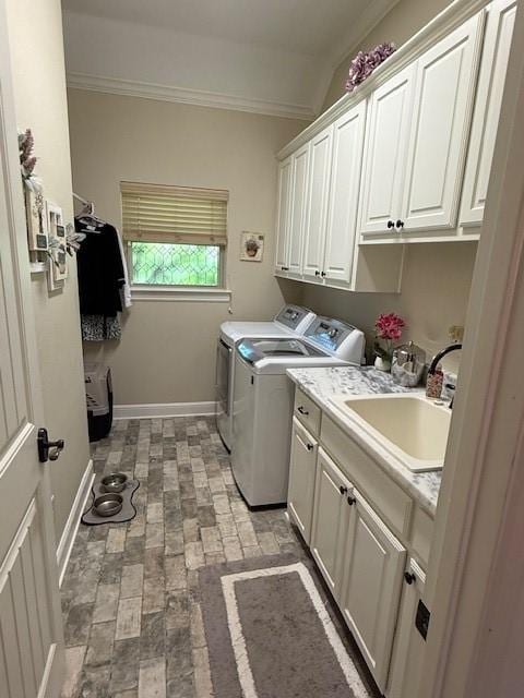 laundry room with cabinet space, a sink, ornamental molding, separate washer and dryer, and brick floor