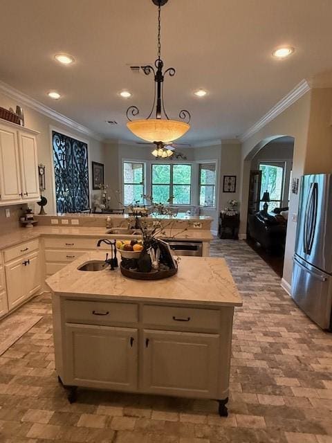 kitchen featuring a sink, ornamental molding, freestanding refrigerator, and recessed lighting