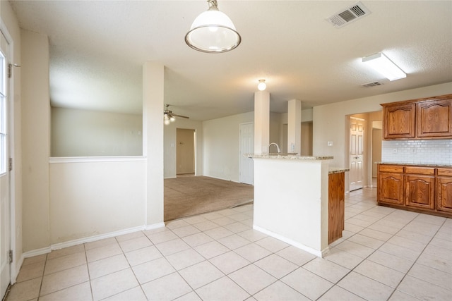 kitchen featuring backsplash, a ceiling fan, visible vents, and light tile patterned floors