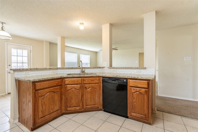 kitchen with a sink, backsplash, black dishwasher, and brown cabinets