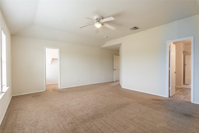 unfurnished room with light colored carpet, ceiling fan, visible vents, and vaulted ceiling