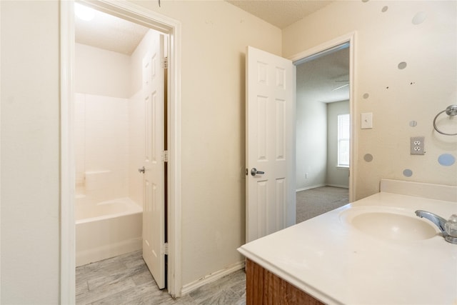 bathroom featuring vanity, baseboards, a textured ceiling, and wood finished floors