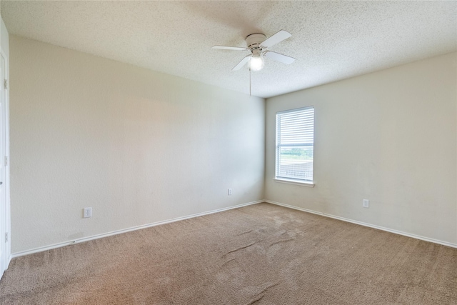 empty room featuring baseboards, carpet flooring, a textured ceiling, and ceiling fan