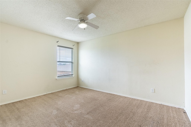 carpeted spare room featuring baseboards, ceiling fan, and a textured ceiling