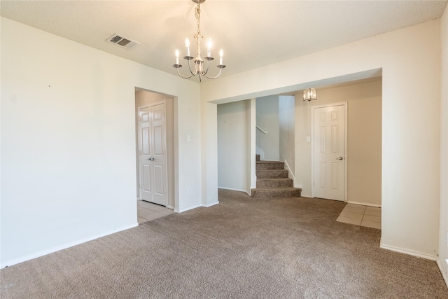 carpeted empty room featuring stairs, a chandelier, baseboards, and visible vents