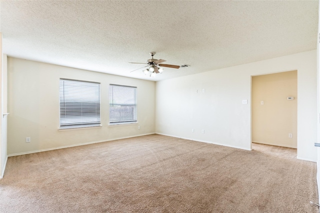 empty room featuring carpet flooring, a ceiling fan, a textured ceiling, and baseboards