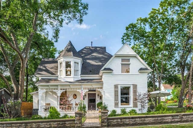 805 Howell St, Mckinney, TX 75069 - victorian house featuring covered porch, a shingled roof, and a fenced front yard