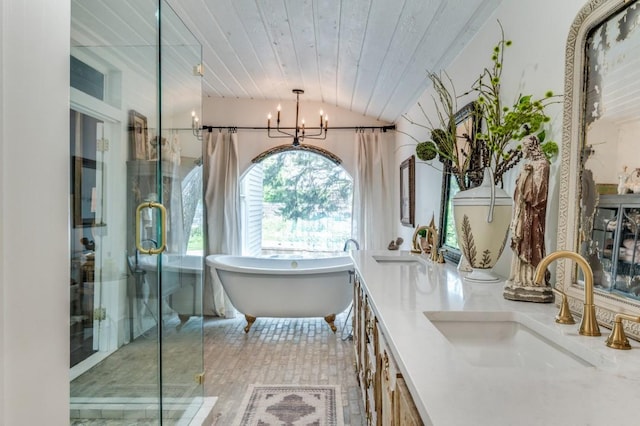 805 Howell St, Mckinney, TX 75069 - bathroom with vaulted ceiling, a soaking tub, double vanity, a chandelier, and a stall shower