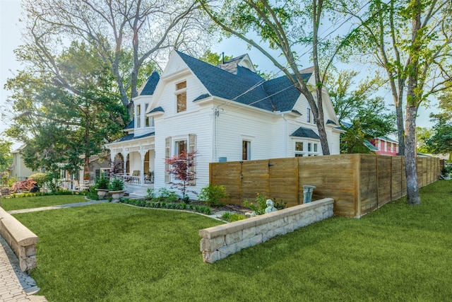 805 Howell St, Mckinney, TX 75069 - view of side of home featuring a porch, a lawn, fence, and roof with shingles
