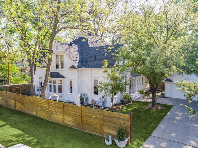 805 Howell St, Mckinney, TX 75069 - view of front of house featuring roof with shingles, fence, an outdoor structure, a garage, and a front lawn
