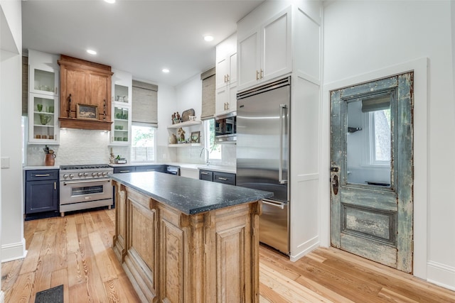 805 Howell St, Mckinney, TX 75069 - kitchen with open shelves, light wood-style floors, built in appliances, a center island, and decorative backsplash