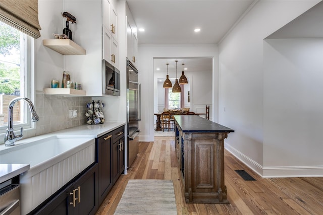 805 Howell St, Mckinney, TX 75069 - kitchen with open shelves, light wood-style floors, a sink, stainless steel appliances, and plenty of natural light