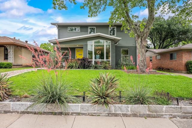 view of front of house with a front lawn and brick siding