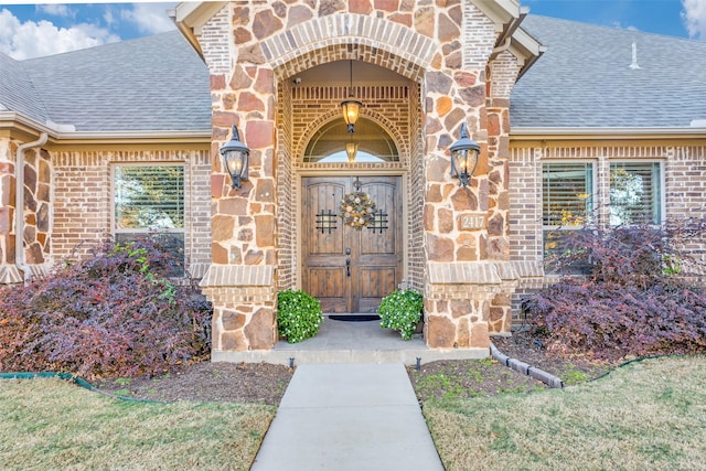 2417 Roosevelt Ave, Fort Worth, TX 76164 - view of exterior entry with brick siding, a shingled roof, and stone siding