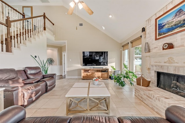 living area featuring a ceiling fan, visible vents, a brick fireplace, high vaulted ceiling, and baseboards