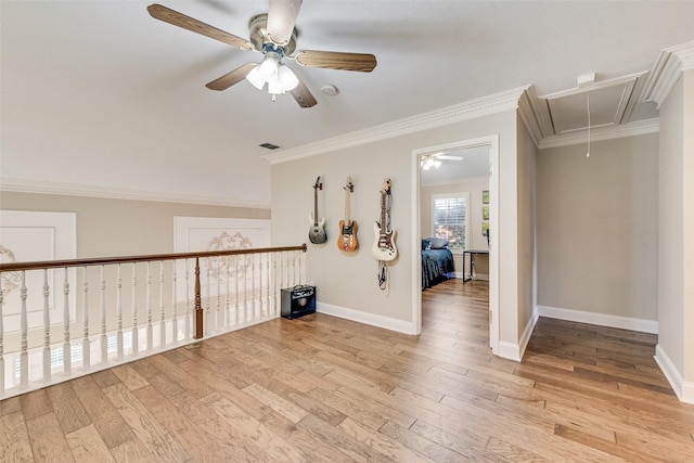 interior space featuring baseboards, ceiling fan, light wood finished floors, and attic access