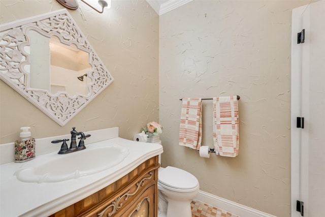 bathroom featuring vanity, ornamental molding, baseboards, and toilet