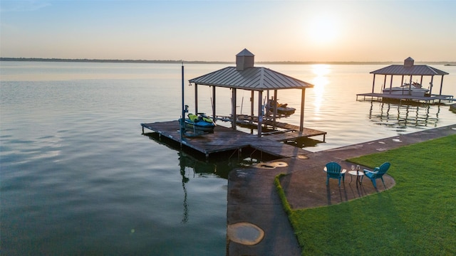 view of dock featuring a lawn, a water view, and boat lift