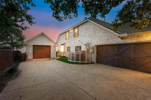 exterior space featuring fence, an outbuilding, and concrete driveway
