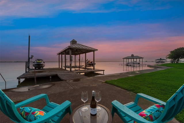 view of dock with a gazebo, a water view, boat lift, and a yard