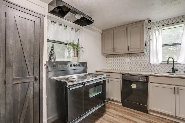 kitchen with a textured ceiling, a sink, black appliances, and tasteful backsplash