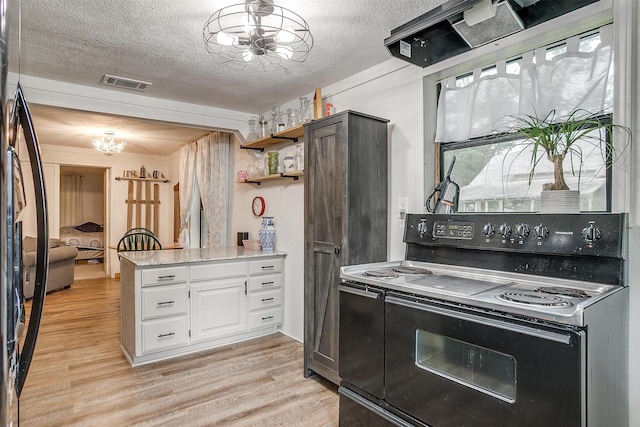kitchen featuring an inviting chandelier, visible vents, light wood-type flooring, white cabinetry, and black range with electric stovetop
