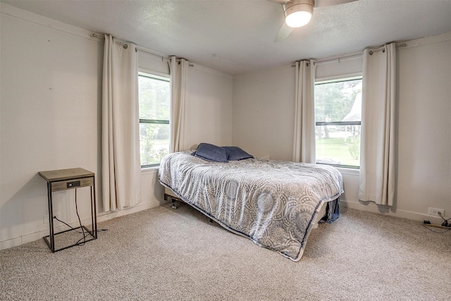 carpeted bedroom featuring baseboards, a ceiling fan, and multiple windows